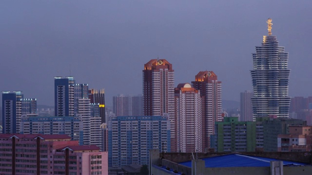 朝鲜平壤未来科学街的未来主义建筑从白天到夜晚的天际线。从高丽饭店看到的。视频素材