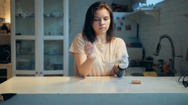 年轻女子正在用她的仿生手换电池视频素材