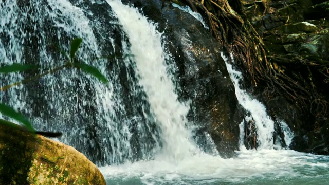 泰国野生丛林森林环境中美丽的瀑布自然风景慢镜头。旅行和冒险的观点，人们走向瀑布视频素材