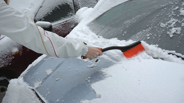 清理车上的积雪。慢镜头清楚视频素材