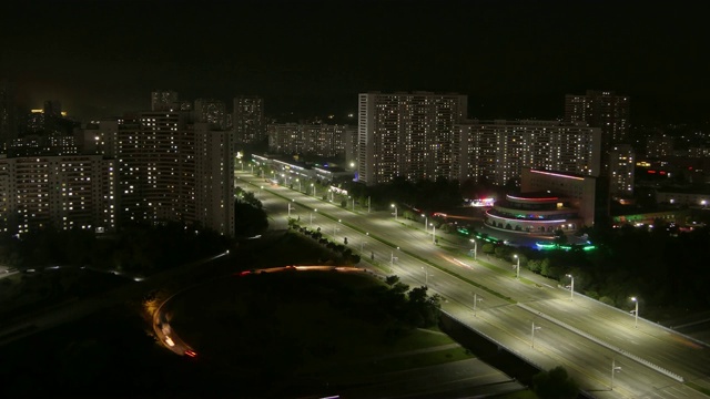 惊人的夜晚时光流逝的住宅建筑和交通在光bok街-宽拍摄的夜晚。朝鲜平壤视频素材