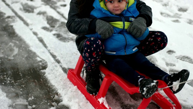 孩子们在雪橇上。雪橇的孩子。冬天的雪的乐趣。视频素材