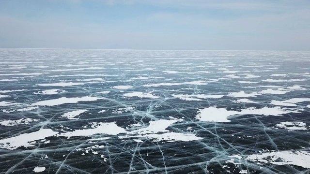 一架无人机在贝加尔湖的冰晶冰面上飞翔。前视图。自然背景和图案视频素材