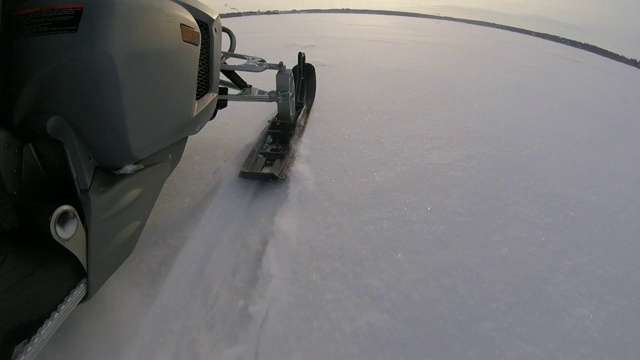 雪地摩托在结冰的湖面上行驶。视频素材