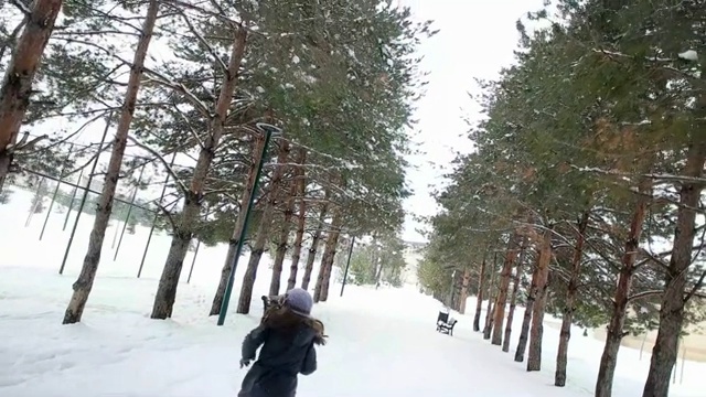 甜美的小女孩在白雪覆盖的公园里奔跑视频素材