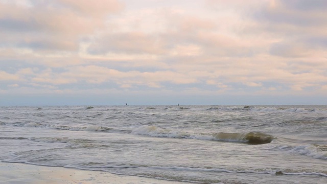 海浪靠近海岸，阳光在水中照耀。风景如画的白沙海岸冲刷着海浪。背景或纹理视频素材