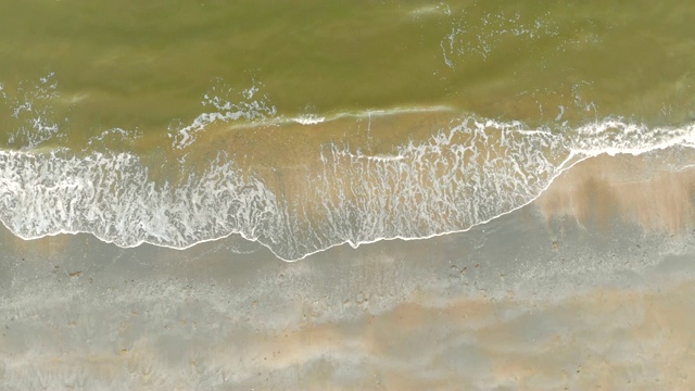 4K沙滩天线，海浪涌向岸边，俯瞰。北海的绿水和灰色的海沙视频素材