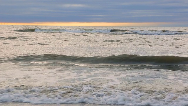 海浪靠近海岸，阳光在水中照耀。风景如画的白沙海岸冲刷着海浪。背景或纹理视频素材