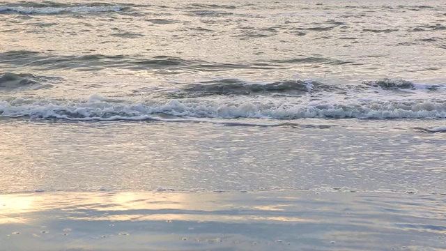 海浪靠近海岸，阳光在水中照耀。风景如画的白沙海岸冲刷着海浪。背景或纹理视频素材