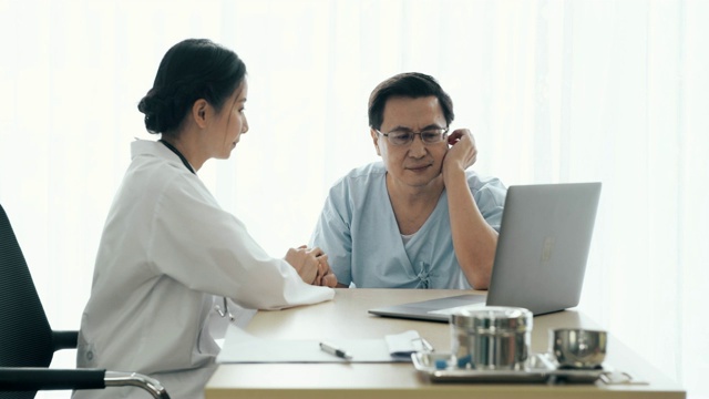 医生和病人。一位年轻女医生在医院里和一位老病人谈话。通过计算机共享医学检测结果。视频素材