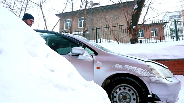 一个男人打开汽车的引擎盖去修理。冬天,下雪视频素材