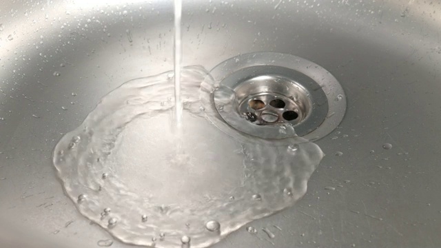 水从水龙头流入不锈钢水槽。视频素材