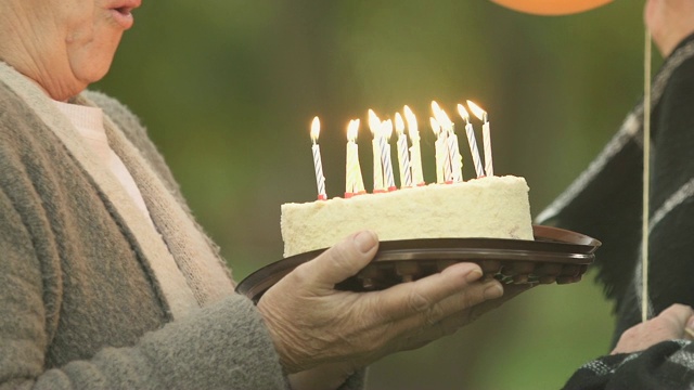 兴奋的老婆婆吹灭生日蜡烛，聚会庆生，长命百岁视频素材