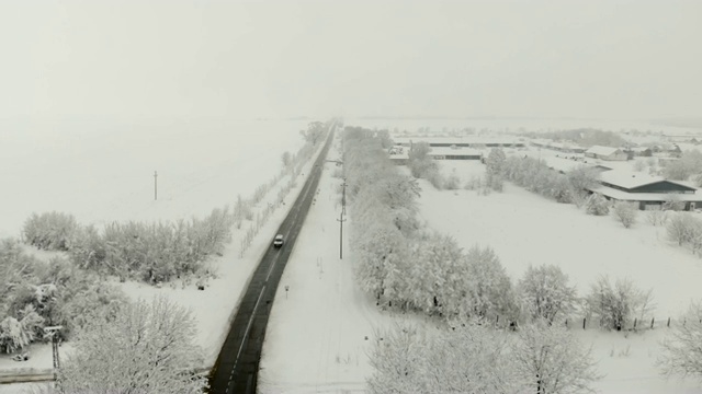 用无人机4K航拍被雪覆盖的村庄。白色多云的冬季天气视频下载