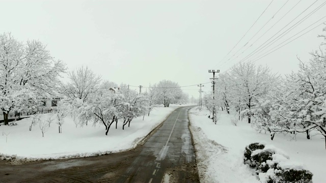 用无人机4K航拍被雪覆盖的村庄。白色多云的冬季天气视频素材