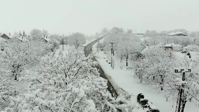 用无人机4K航拍被雪覆盖的村庄。白色多云的冬季天气视频素材