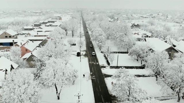 用无人机4K航拍被雪覆盖的村庄。白色多云的冬季天气视频下载