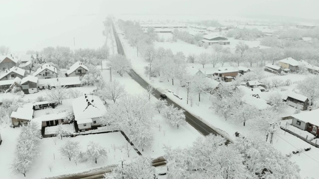 用无人机4K航拍被雪覆盖的村庄。白色多云的冬天天气。视频素材