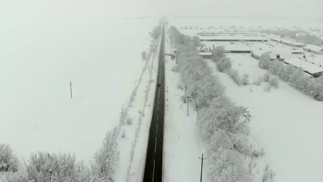 用无人机4K航拍被雪覆盖的村庄。白色多云的冬季天气视频素材