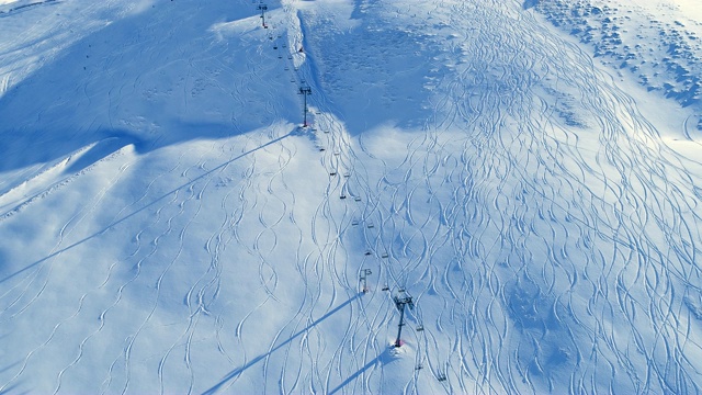 雪山中移动滑雪缆车的惊人鸟瞰图。冬季滑雪和单板滑雪的好天气。视频素材