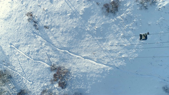 鸟瞰图上方移动滑雪缆车。在雪山滑雪缆车的视野。冬季滑雪和单板滑雪的好天气。视频素材