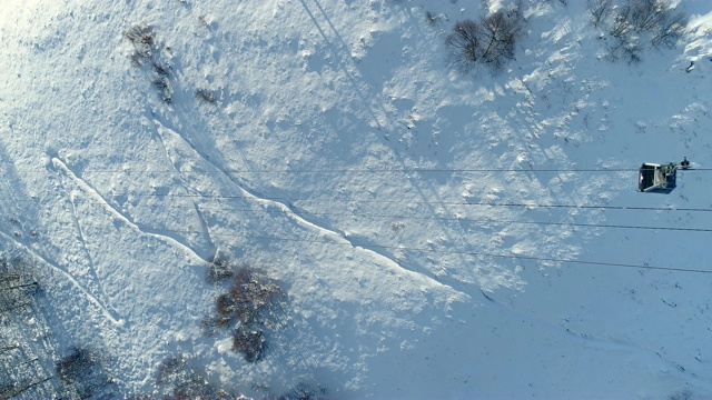 高山滑雪胜地滑雪缆车的鸟瞰图。在雪山滑雪缆车的视野。冬季滑雪和单板滑雪的好天气。视频素材