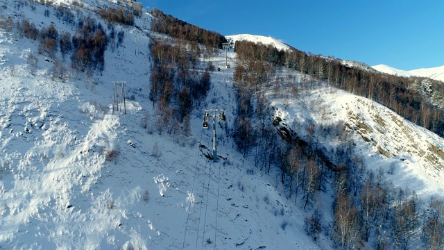 森林里的滑雪缆车景色令人惊叹。鸟瞰图滑雪缆车在雪山。冬季滑雪和单板滑雪的好天气。视频素材