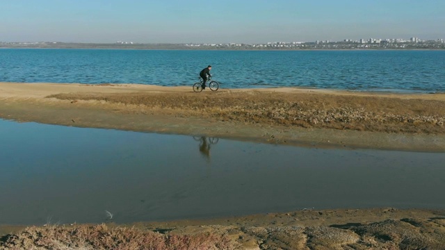 在秋日的湖边，人们骑着山地车。从无人机拍摄视频素材