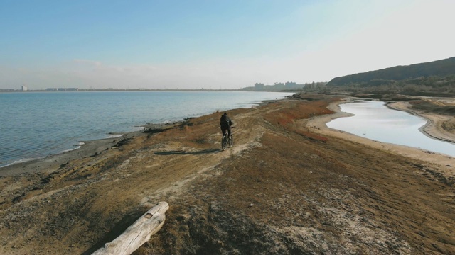 在秋日的湖边，人们骑着山地车。从无人机拍摄视频素材