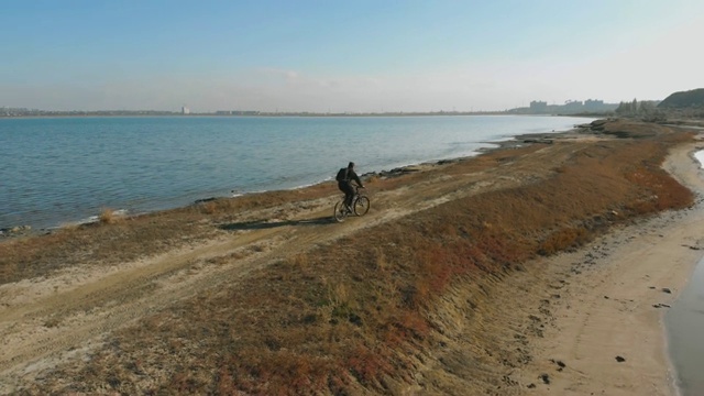 在秋日的湖边，人们骑着山地车。从无人机拍摄视频素材