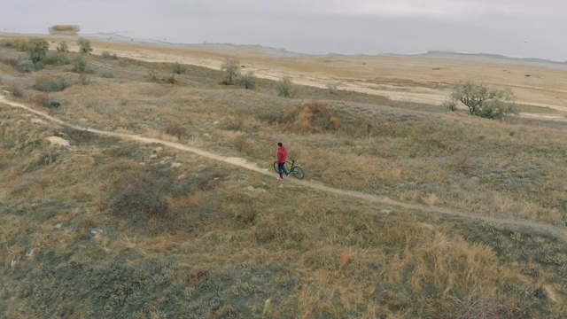 在秋日的湖边，人们骑着山地车。从无人机拍摄视频素材