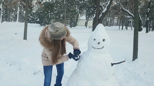 女人和雪人玩得开心视频素材