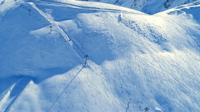 雪山滑雪坡道和滑雪缆车的空中天线。冬季滑雪和单板滑雪的好天气。视频素材