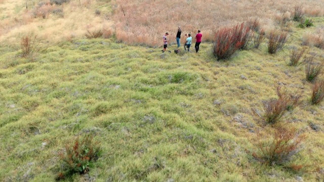 航拍:年轻男子在风景优美的废墟小屋前拍照视频素材