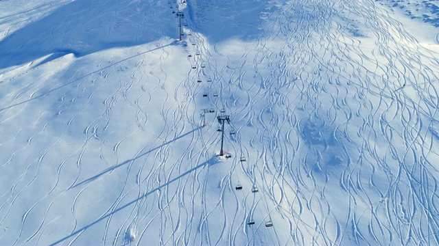 滑雪缆车和滑雪者在滑雪轨道上的鸟瞰图。在雪山滑雪缆车的视野。冬季滑雪和单板滑雪的好天气。视频素材