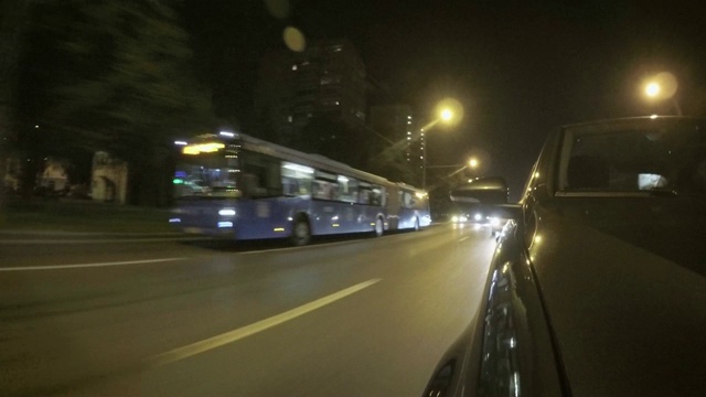 汽车在夏天的夜晚沿着城市的街道行驶。前视图从引擎盖。视频素材