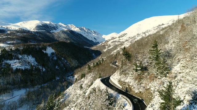 4 × 4山路鸟瞰图。在一个阳光明媚的日子里，一辆车行驶在山路上。法国的山脉被雪覆盖着。寒假的好天气视频素材