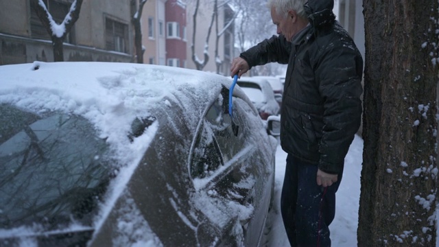 一位老人正在除雪，试图钻进他的车里视频素材