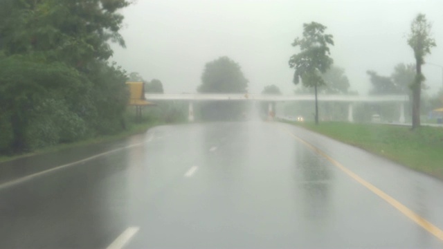 POV，公路旅行，在雨中缓慢驾驶汽车穿过挡风玻璃，雨刷正在清除雨水。在有限速标志的湿滑公路上驾驶汽车。4 k视频。视频素材