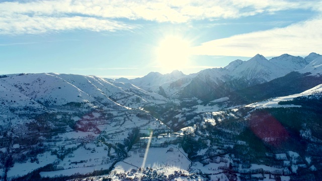 美丽的雪村在阳光明媚的日子里，冬天的景色。鸟瞰图后面的村庄山脉，一个冬天的风景。法国的山脉被雪覆盖着。视频素材