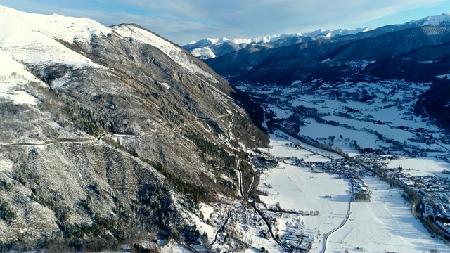 航拍下雪山和雪村，一派冬日风光。村庄后面的山脉，冬天的风景。法国的山脉被雪覆盖着。视频素材