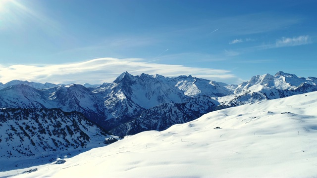 美丽的航拍山景覆盖着雪，野生的自然风光。在一个阳光明媚的日子里，在滑雪胜地用滑雪缆车航拍。冬天滑雪的好天气。视频素材