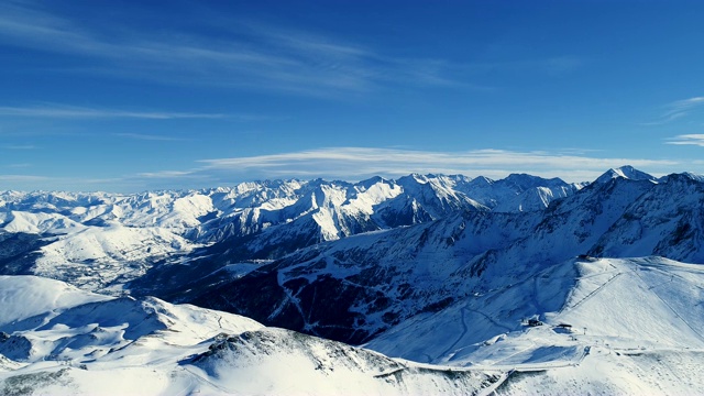 在一个阳光明媚的冬日里，在覆盖着积雪的山景之上拍摄。法国的山顶被雪覆盖着。冬天令人放松的白色风景。视频素材