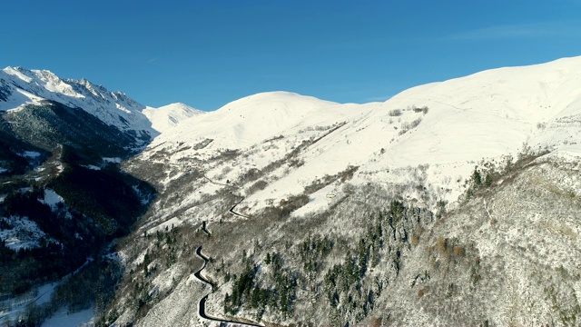 鸟瞰图在一个阳光明媚的日子在岩石山的道路。法国的山顶被雪覆盖着。冬天令人放松的白色风景。视频素材