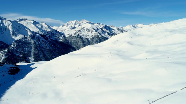 鸟瞰图的高山滑雪度假村在冬天在一个晴朗的日子。法国的山顶被雪覆盖着。冬天令人放松的白色风景。视频素材