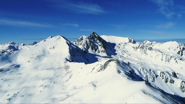 飞越欧洲蓝天下白雪覆盖的山顶。法国的山顶被雪覆盖着。冬天令人放松的白色风景。视频素材