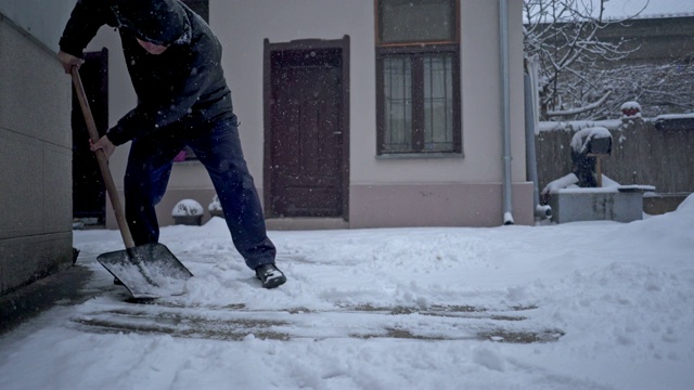 老人在院子里铲雪视频素材