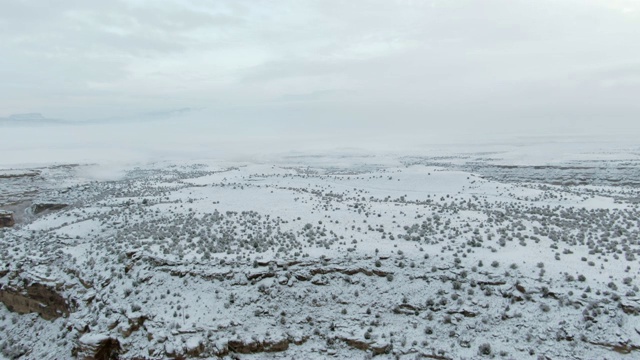 上升的无人机拍摄的雪景，岩石沙漠在冬天下阴天视频素材