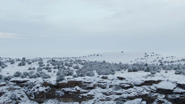 无人机拍摄的一个下雪，岩石沙漠景观在冬天下阴天视频素材