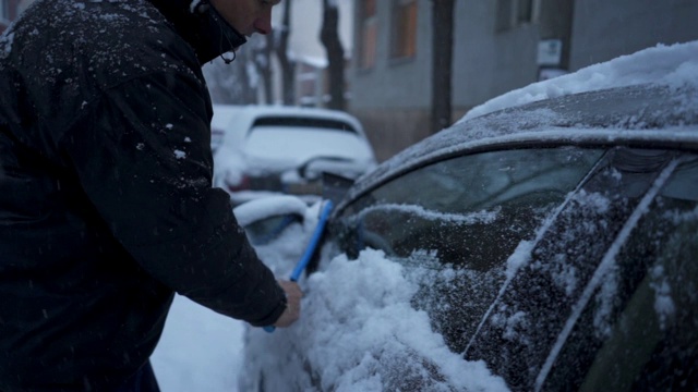 一位老人在暴风雪后清洗他的汽车视频素材